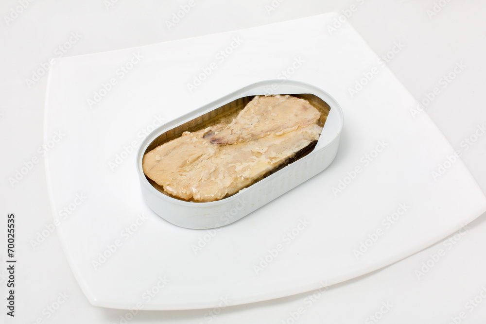 open can of fish in a plate on a white background open can of fish in a plate on a white background