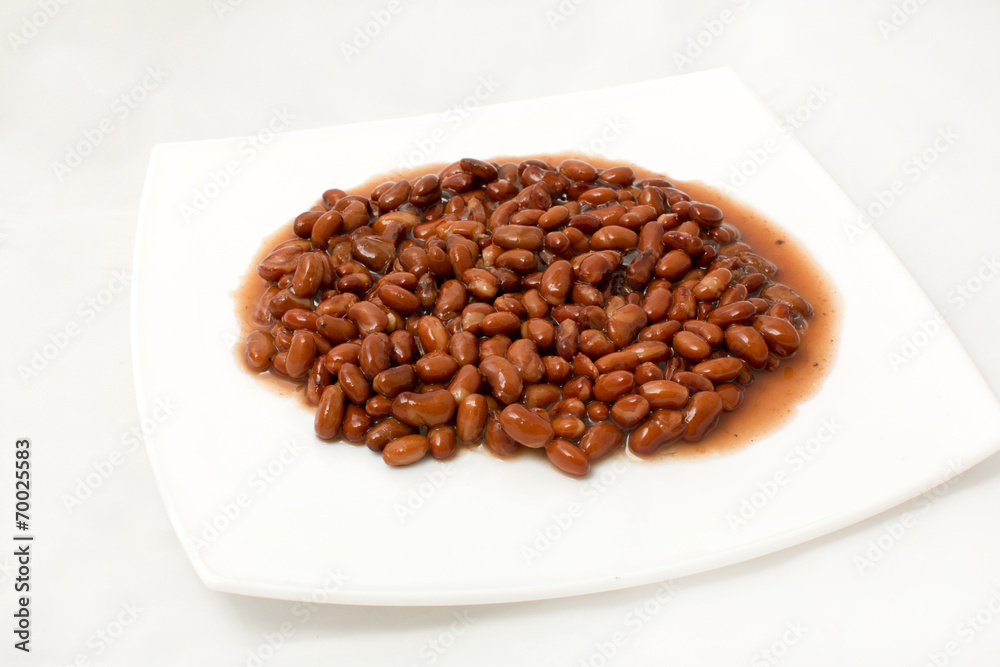 An overhead view of canned black beans on a white background