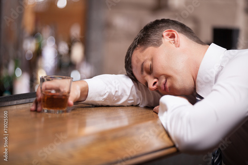 Drunk and unconscious businessman lying on counter.