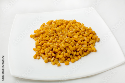 Large grain of corn in a dish on a white background