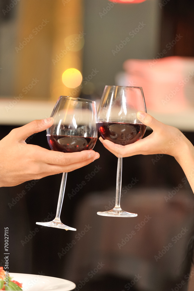 Two people toasting with wine glasses.