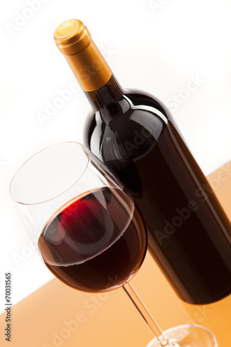 Ein Glas Rotwein mit Flasche daneben