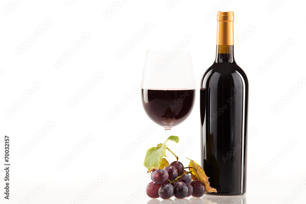 Rotwein im Glas mit Flasche und Weintrauben