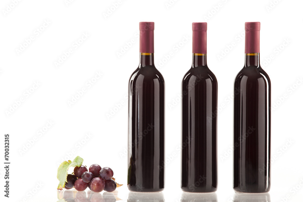 Obraz premium Rotwein im Glas mit Frucht, Blätter und Weinflasche