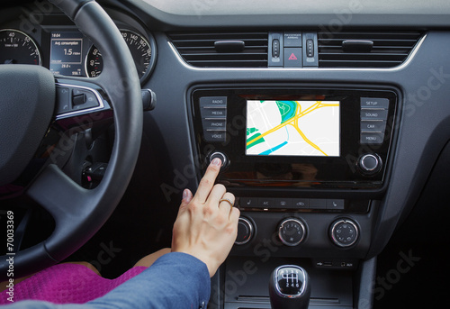 Wall Mural Woman using navigation system while driving a car