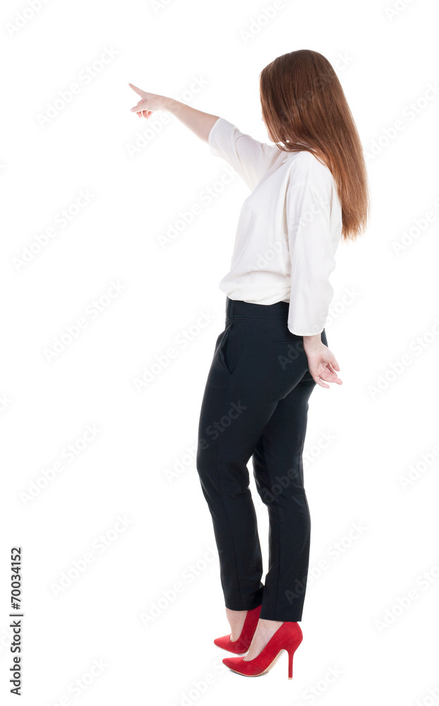 Back view of young redhead business woman pointing at wal Back view of young redhead business woman pointing at wal