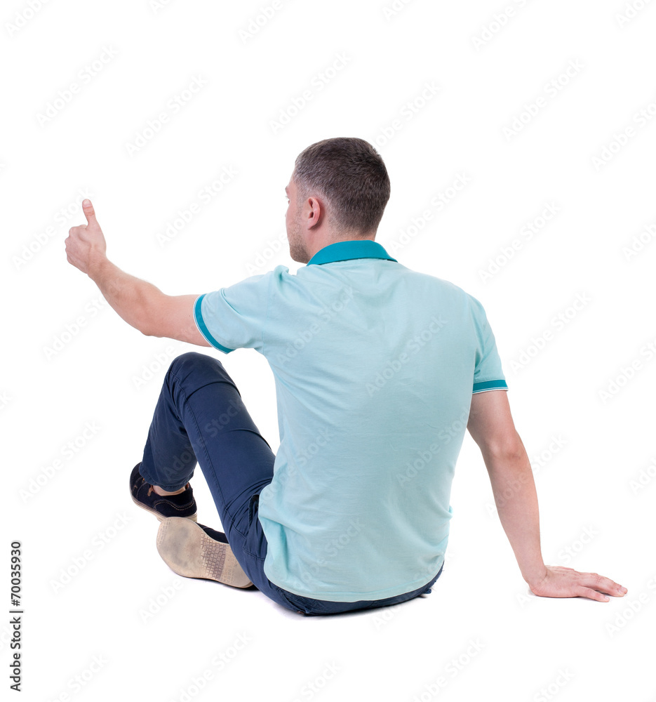 Back view of man in checkered shirt shows thumbs up. sitting ma Back view of man in checkered shirt shows thumbs up. sitting ma