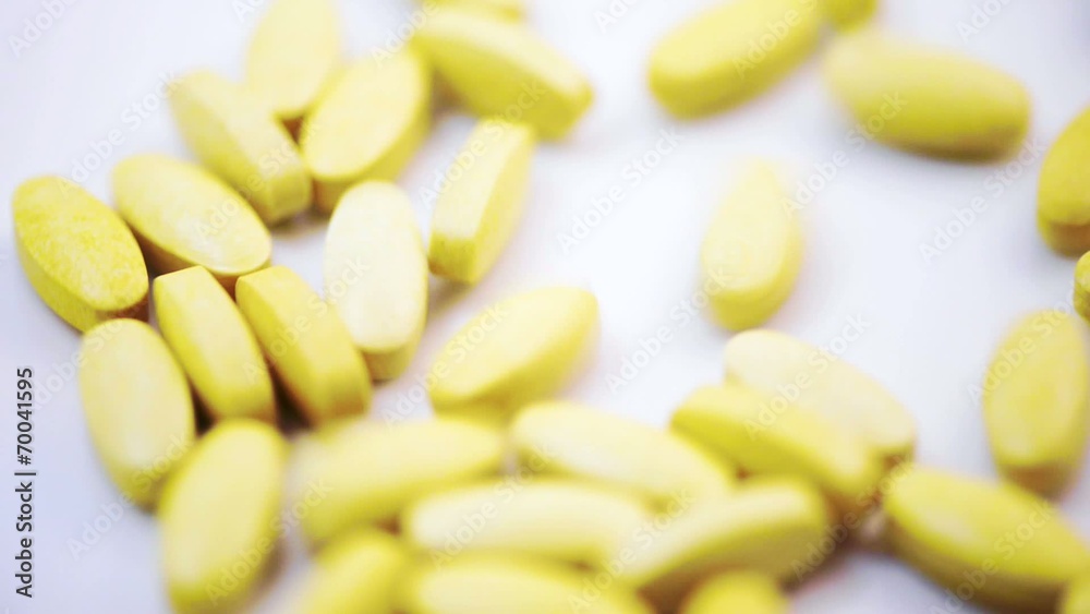 Pile of Vitamin C tablets pouring from container Pile of Vitamin C tablets pouring from container