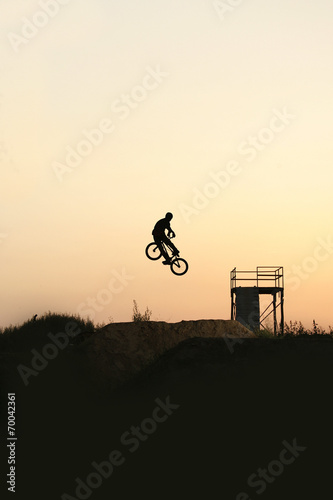 Silhouette of a young rider on a bike in the bike park.