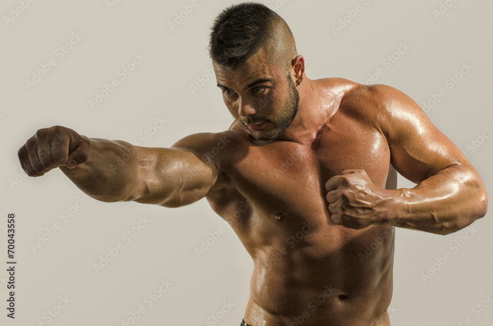 Strong bodybuilder punching and training in boxing Strong bodybuilder punching and training in boxing