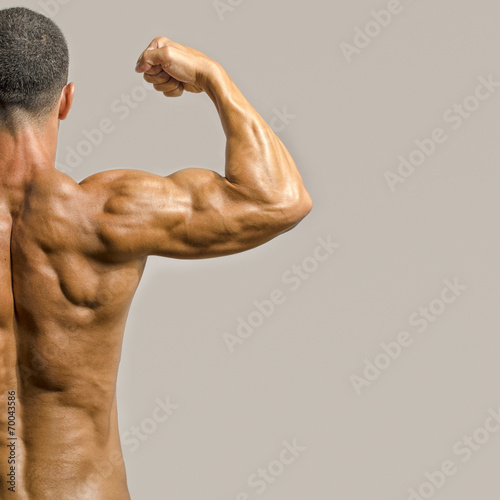 Bodybuilder showing his back and biceps muscles, fitness trainer