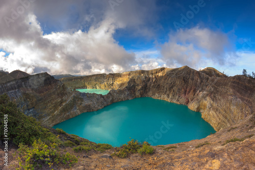 Steaming voulcanic colorful lakes in Kelimutu kraters on a brigh photo