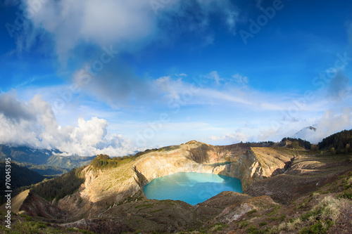 Steaming voulcanic colorful lakes in Kelimutu kraters on a brigh photo