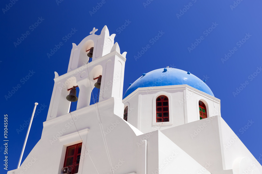A white church with blue dome in Oia. Santorini island, Greece.