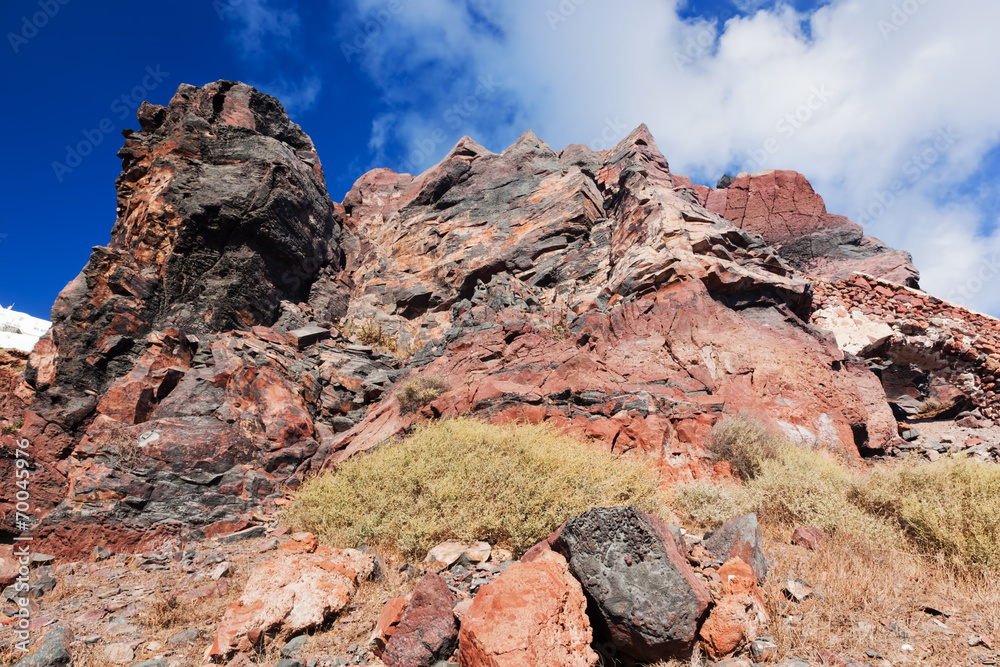 Cliff and volcanic red rocks of Santorini island, Greece. - obrazy, fototapety, plakaty 