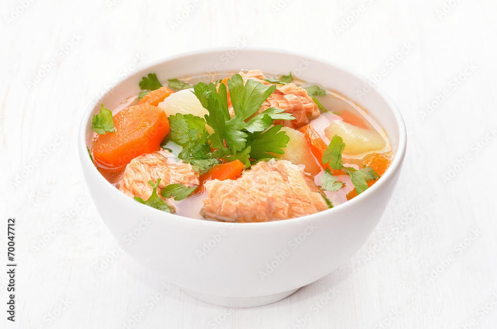 Fish soup with salmon in white bowl