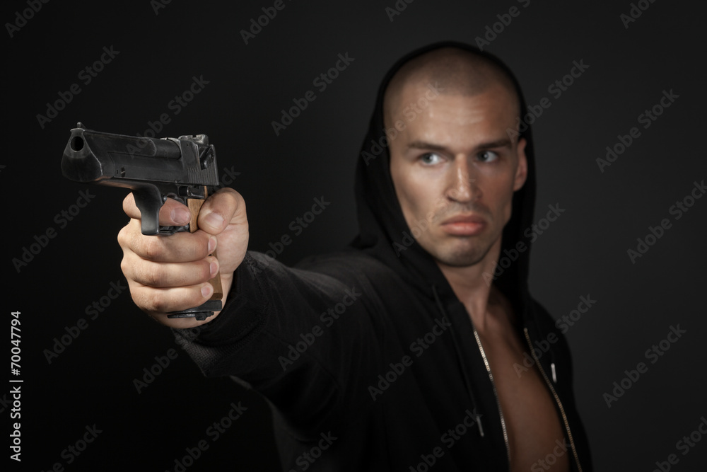 man shooting gun isolated on gray background. focus on gun man shooting gun isolated on gray background. focus on gun