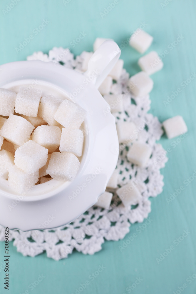 White refined sugar in sugar bowl on color wooden background White refined sugar in sugar bowl on color wooden background