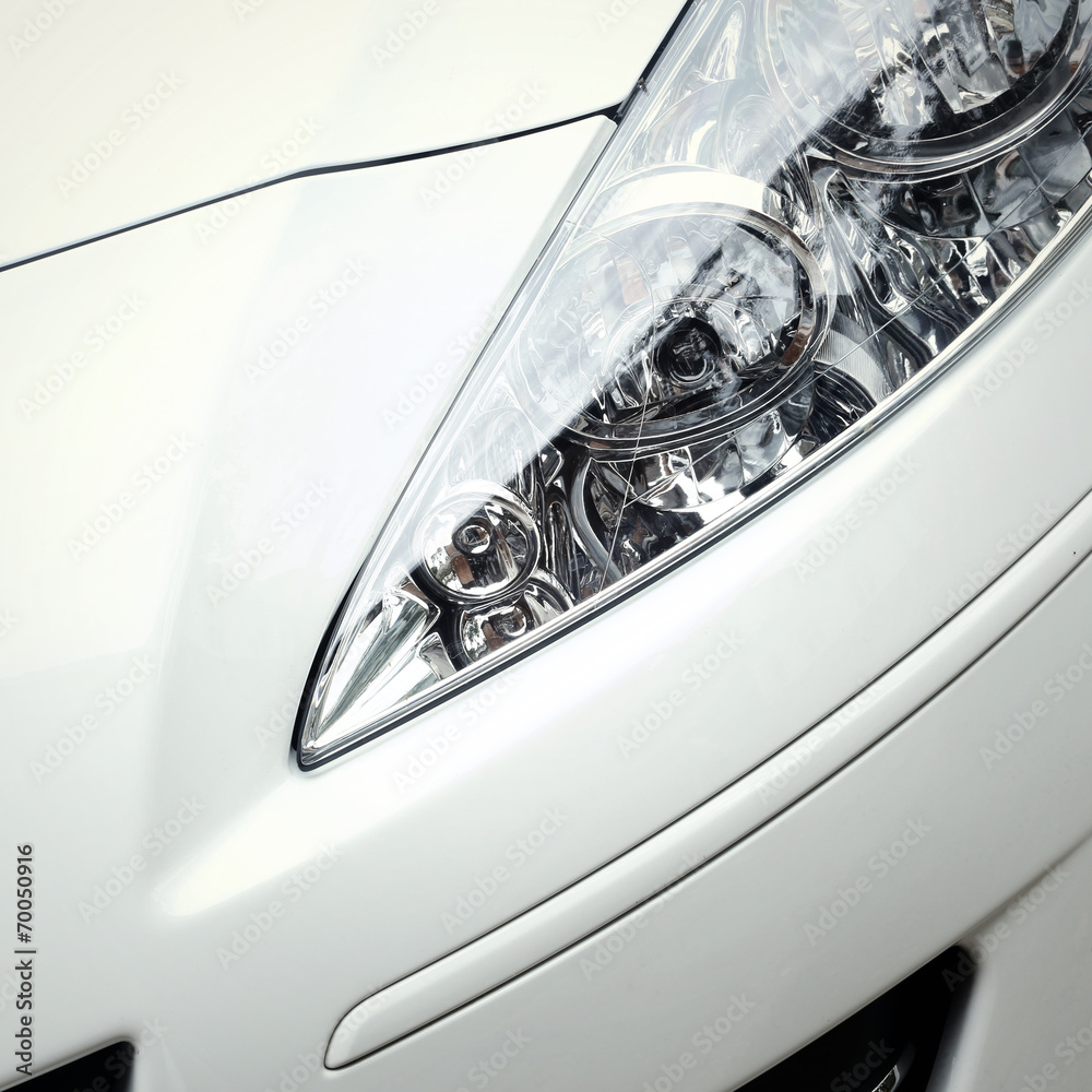 Detail on the headlight of a white car
