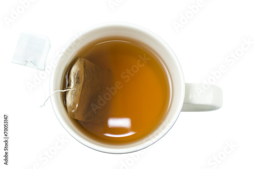 Closeup of a cup of tea and teabag viewed from above, isolated photo