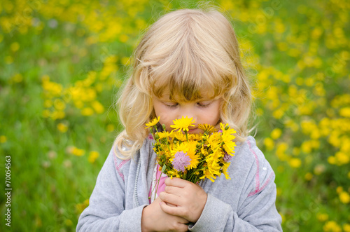 blond girl smelling flowers