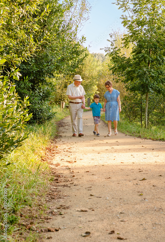 Grandparents and grandchild walking outdoors Grandparents and grandchild walking outdoors