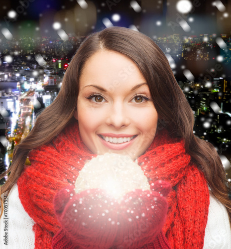 smiling woman in winter clothes with snowball