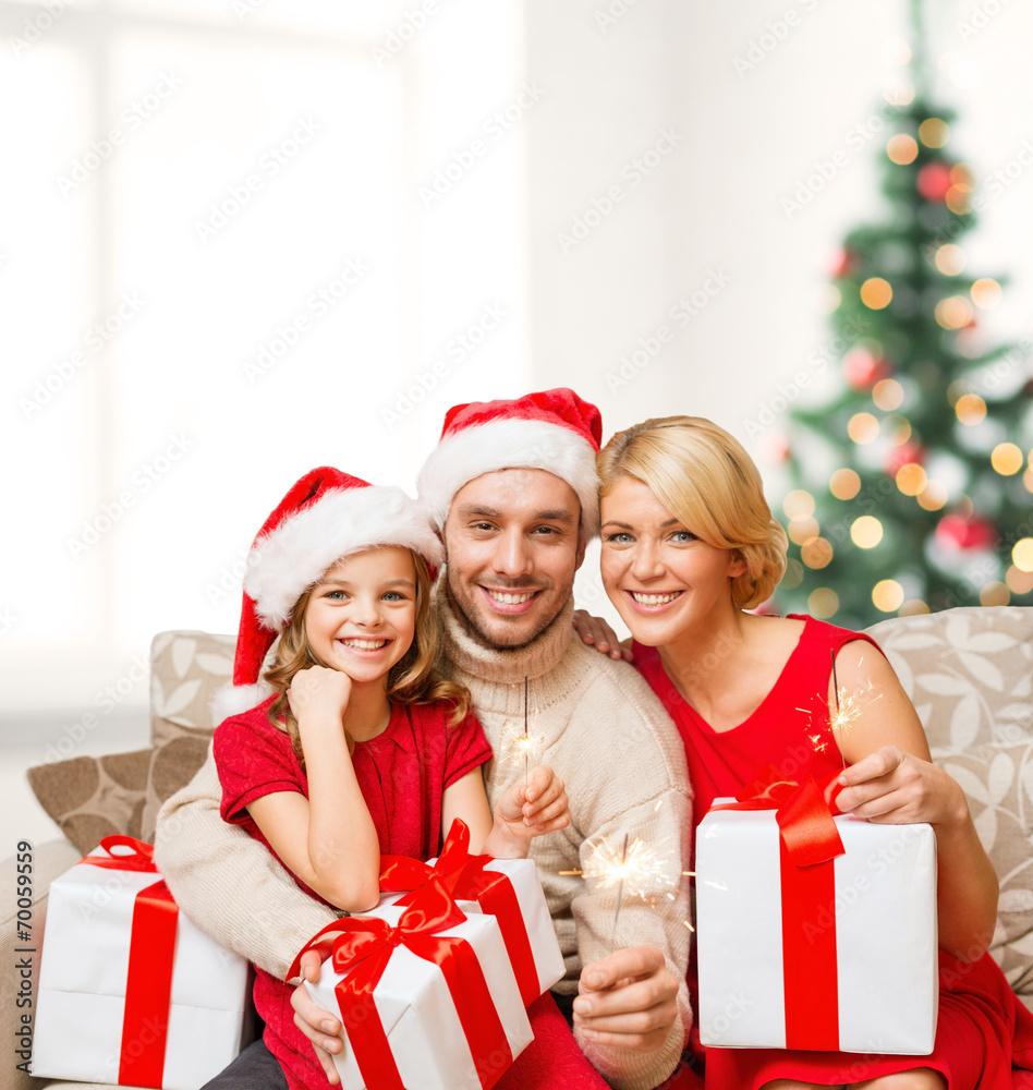 smiling family holding gift boxes and sparkles smiling family holding gift boxes and sparkles