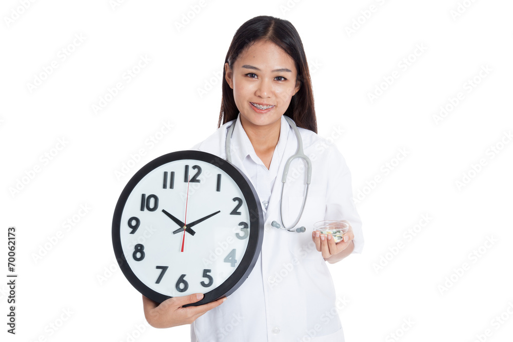 Young Asian female doctor smile with a clock and pills Young Asian female doctor smile with a clock and pills
