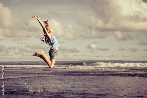 Photography teen girl  jumping on the beach at blue sea shore in summer vaca