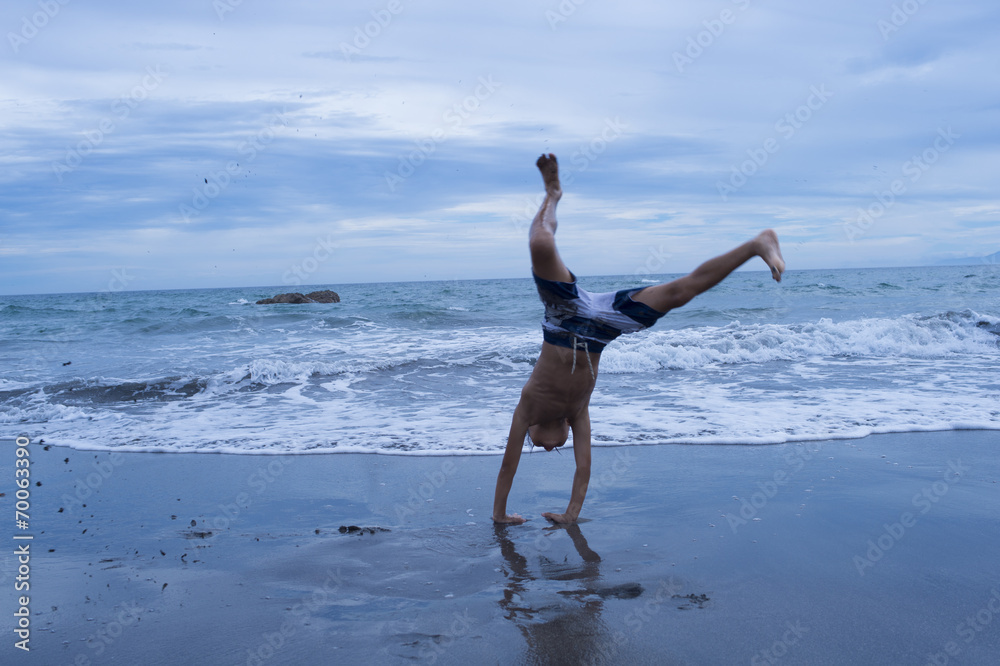 Boy to handstand on the beach