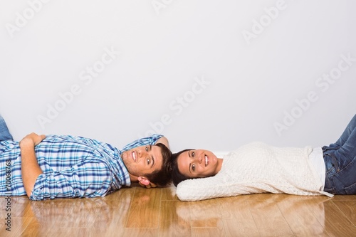 Young couple lying on floor smiling