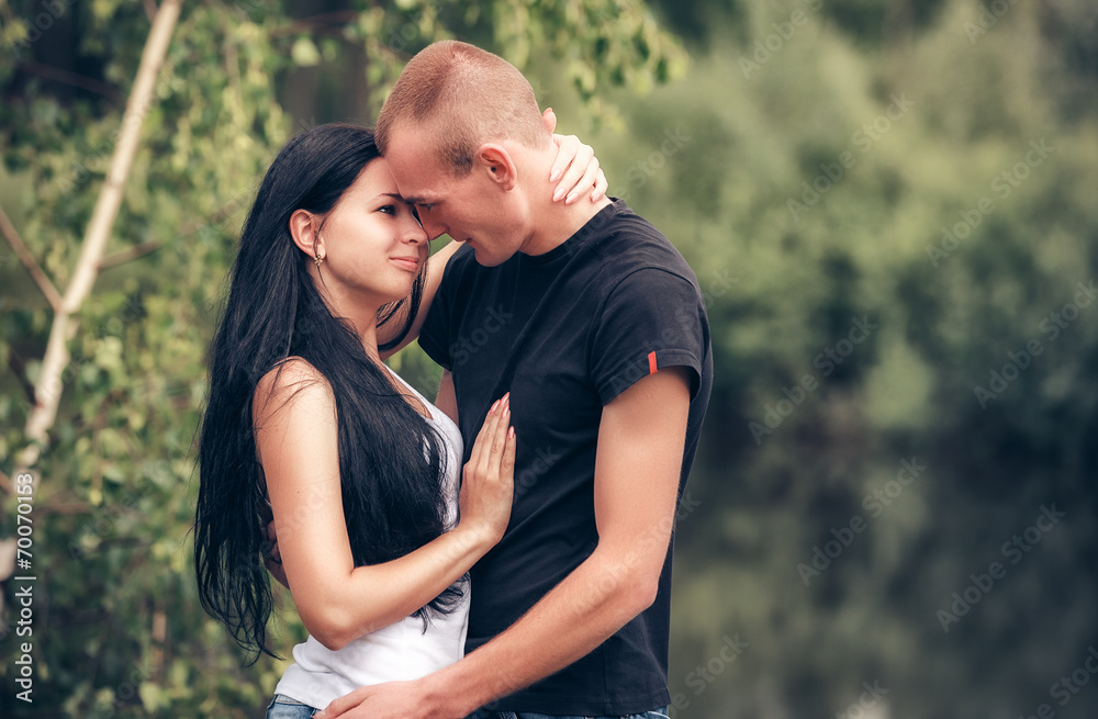Love and affection between a young couple at the park Love and affection between a young couple at the park