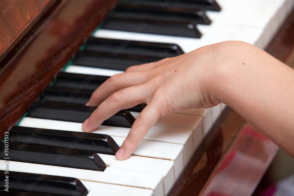 Fototapeta premium Close up of child's hands playing the piano