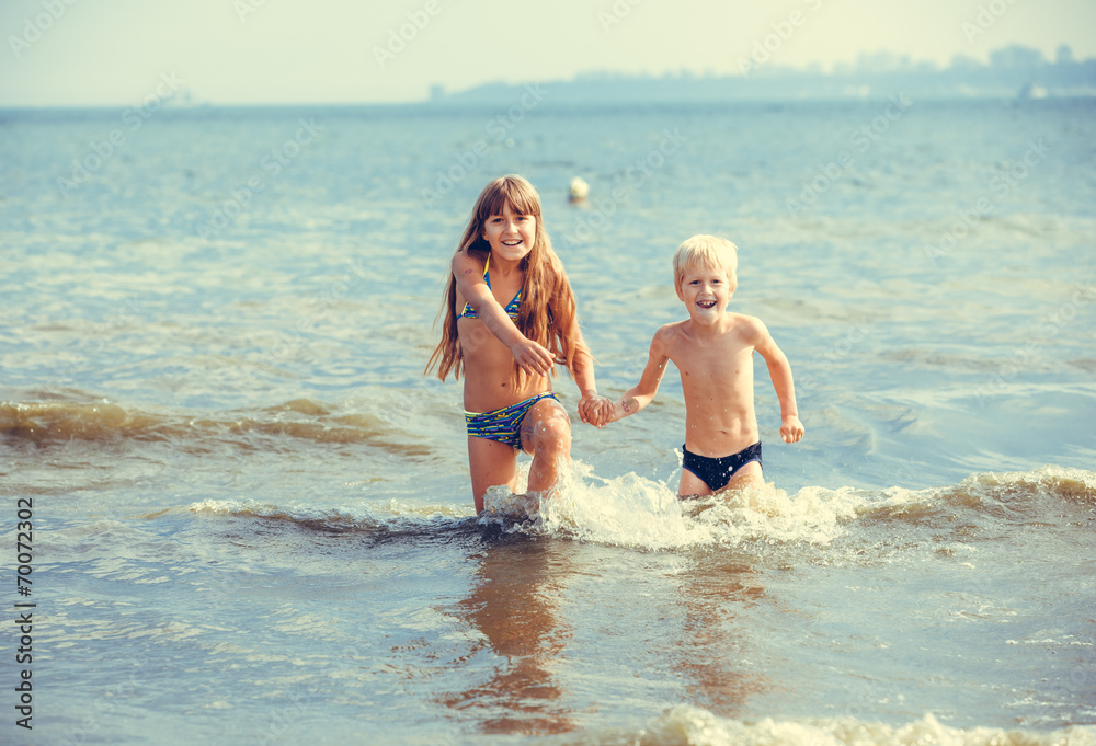 happy little girl and boy in the sea