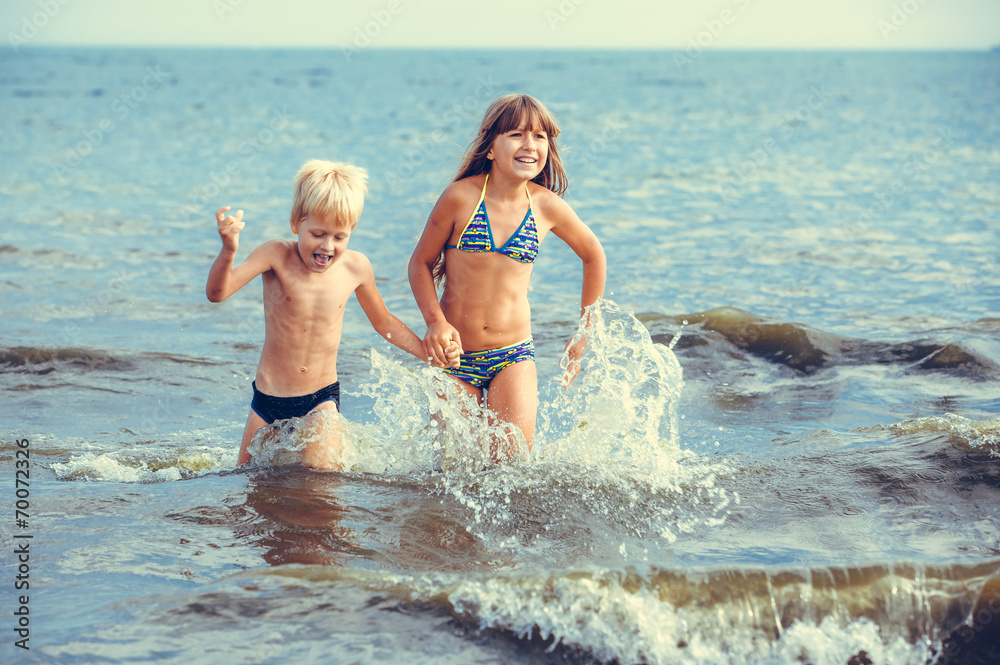happy little girl and boy in the sea happy little girl and boy in the sea