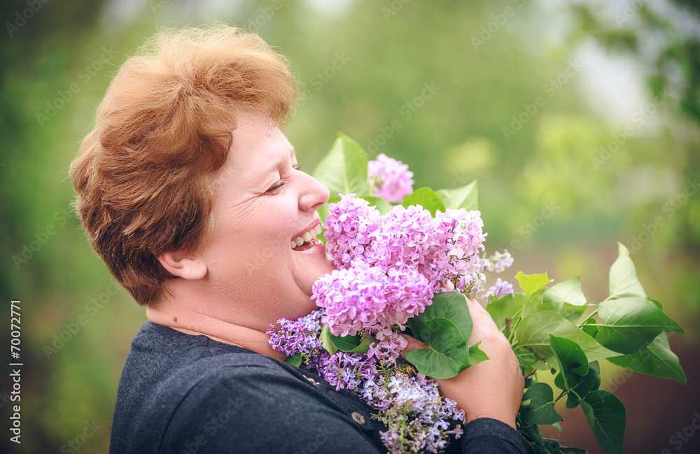 woman in park with a big bouquet of a lilac