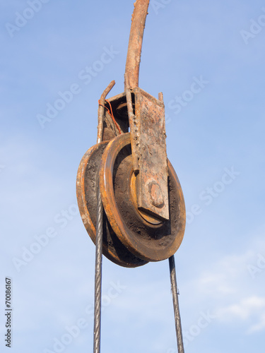 The rusty iron pulley with blue sky background