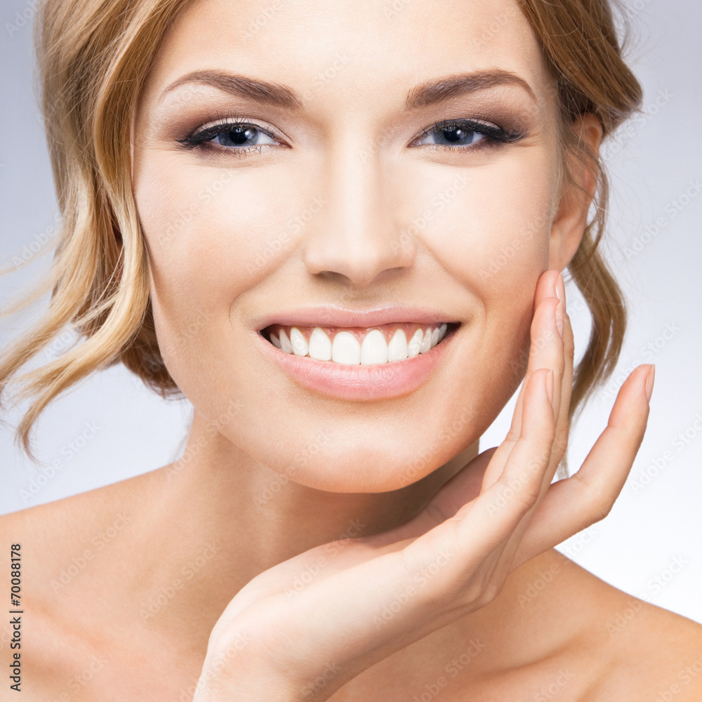 Fototapeta premium Woman touching skin or applying cream, on grey