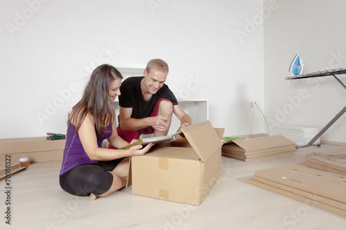 Young Couple Moving, Looking at Old Pictures