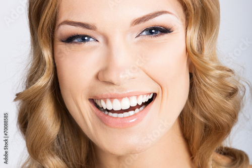 Young cheerful smiling woman  on gray