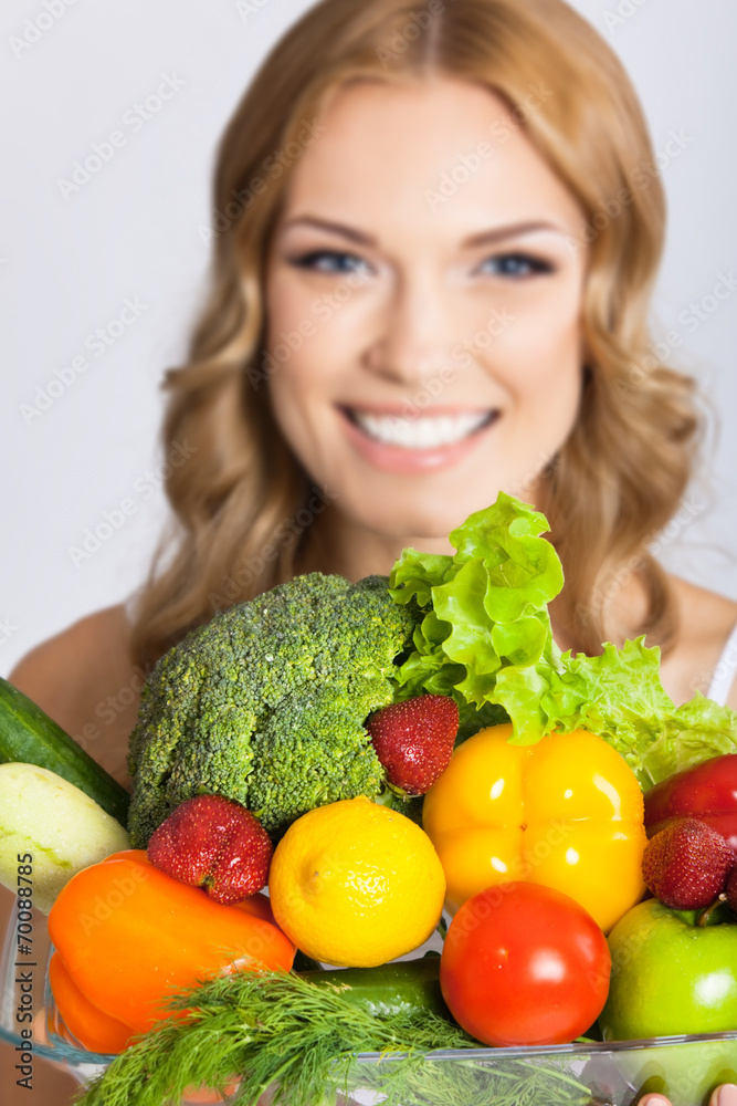 Young woman with vegetarian food, over gray Young woman with vegetarian food, over gray