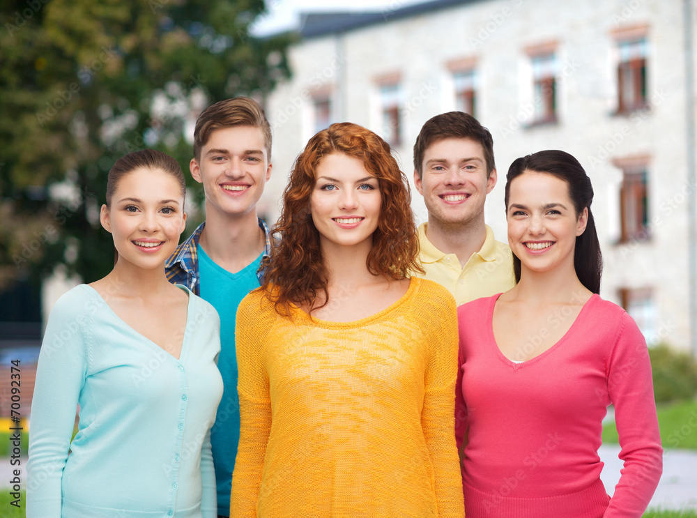 group of smiling teenagers over campus background group of smiling teenagers over campus background