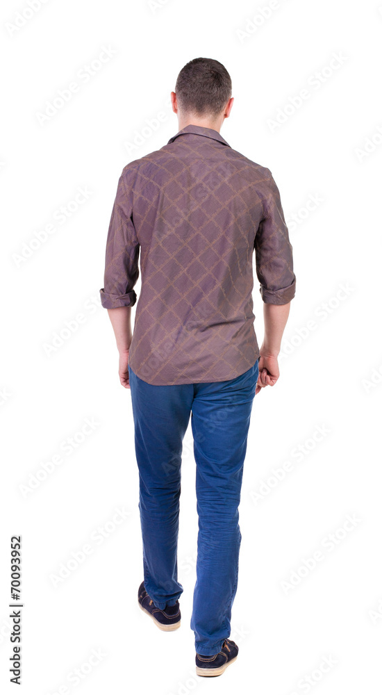 Back view of going handsome man in jeans and a shirt. Back view of going handsome man in jeans and a shirt.