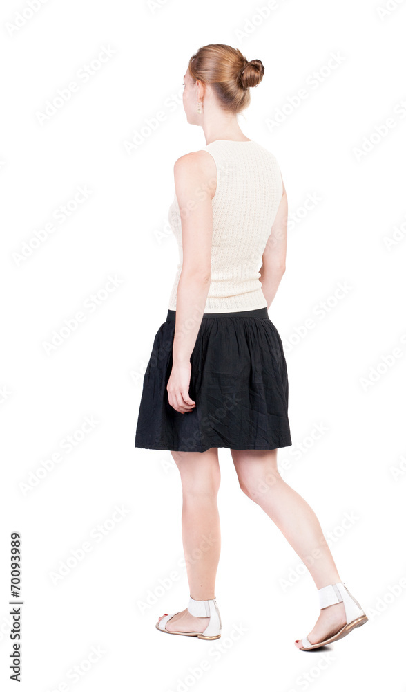 Fototapeta premium back view of walking woman in dress. beautiful blonde girl in m