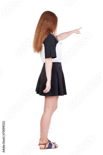 Back view of young redhead woman pointing at wall. beautiful gir © ghoststone