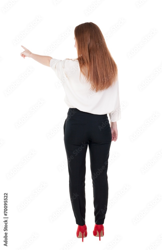 Back view of young redhead business woman pointing at wal Back view of young redhead business woman pointing at wal