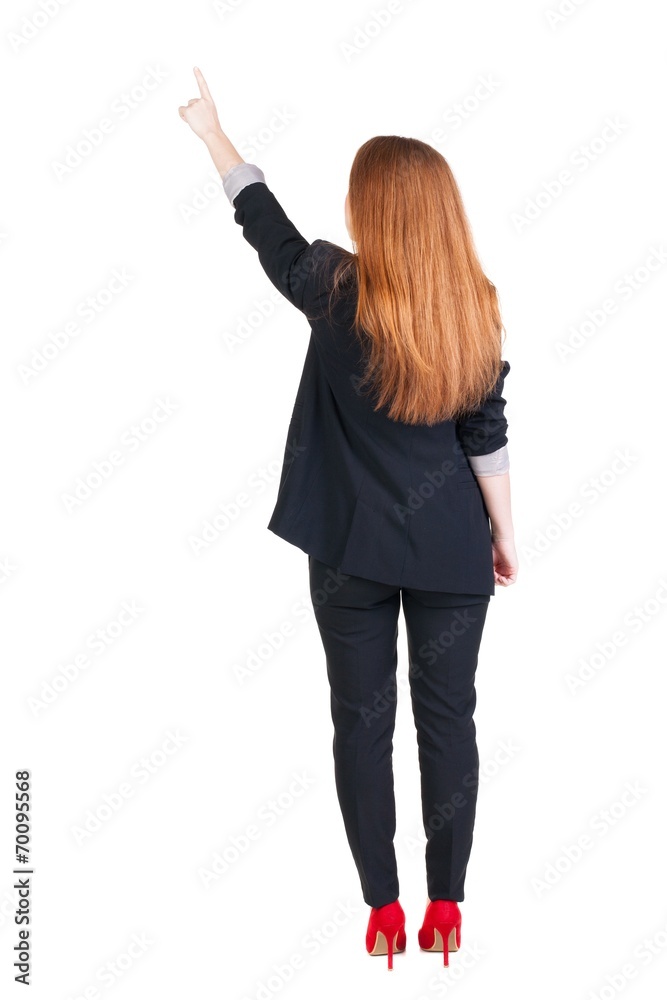 Back view of young redhead business woman pointing at wal