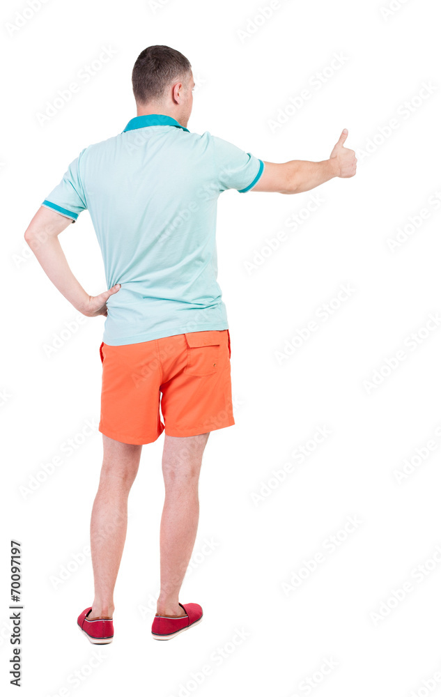 Back view of  man in shorts shows thumbs up.