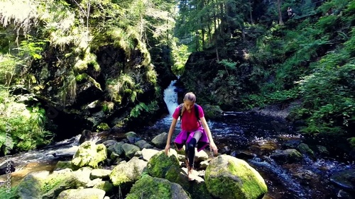 young woman hiking by a river